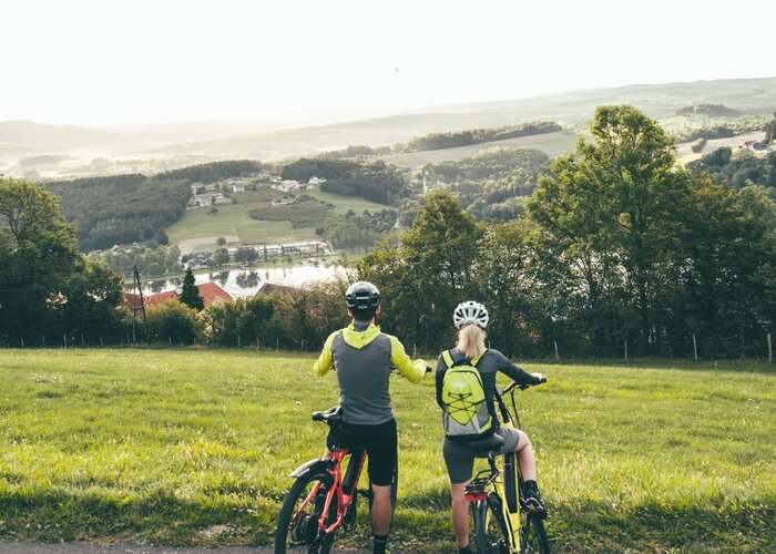 Radfahrer blicken auf den Stubenbergsee in der Oststeiermark | cmvisuals | © Oststeiermark Tourismus, cmvisuals