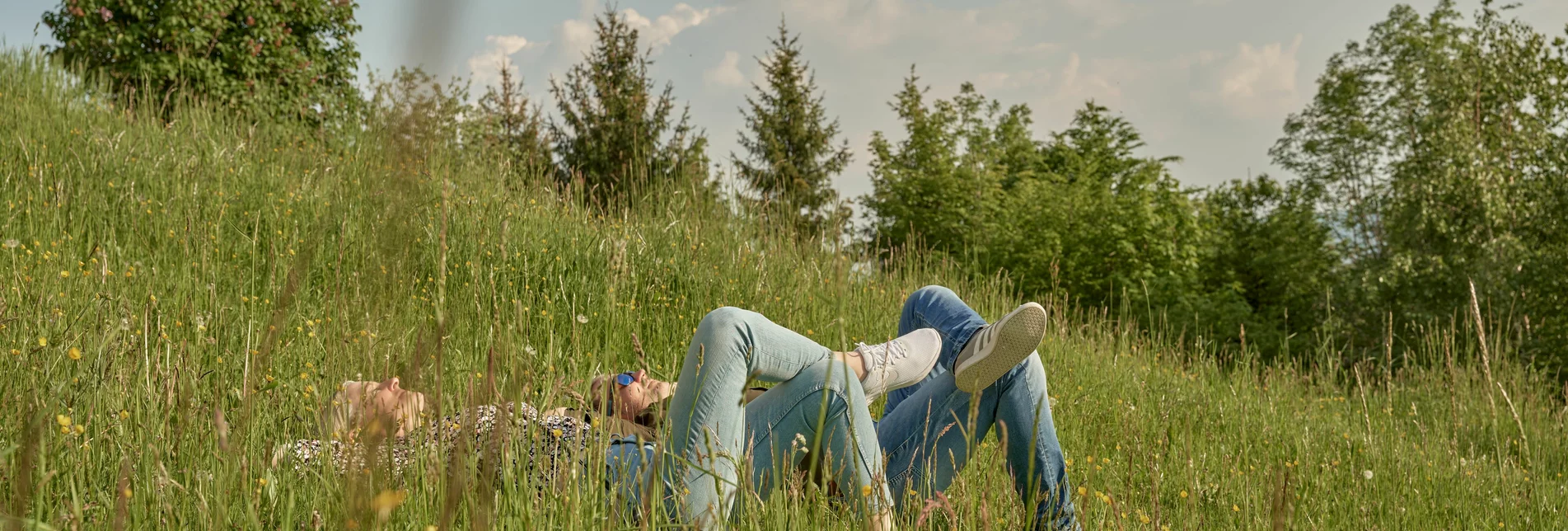 Couple lying on the meadow in the sun on the Pöllauberg in Eastern Styria | ©  Oststeiermark Tourismus | Markus Lang-Bichl