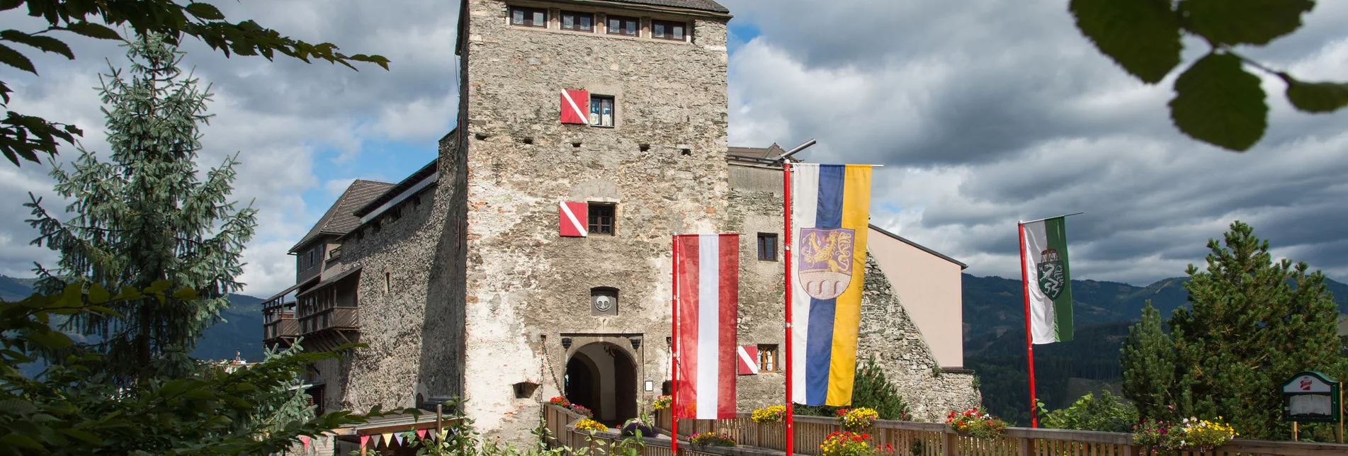 Eine Burg mit Zugbrücke, Blumen und Fahnen