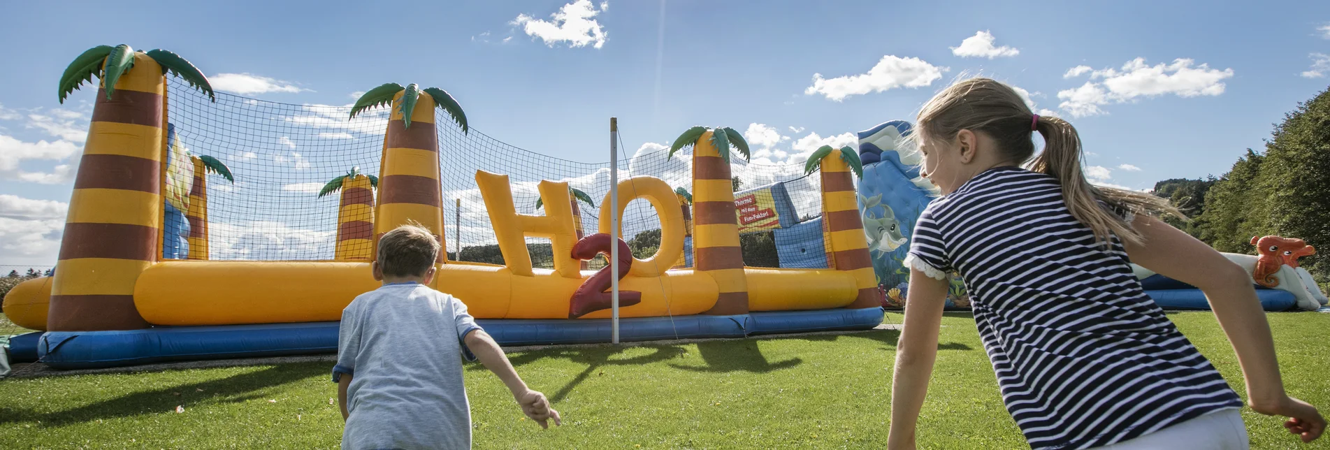 Zwei Kinder vor einer riesigen Hüpfburg | © H2O Hoteltherme GmbH