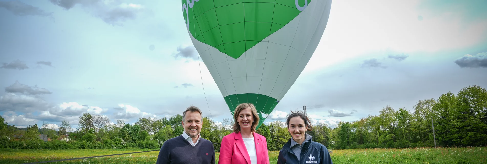 Landesrätin Barbara Eibinger-Miedl und Michael Freitag mit Ballonpilotin Elisabeth Kindermann-Schön bei der Taufe des neuen herzgebrandeten Racerheißluftballons.   | © STG | Jesse Streibl