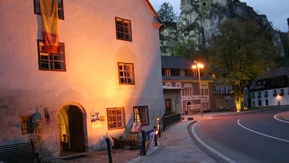 Altes Haus und Burgruine im Hintergrund