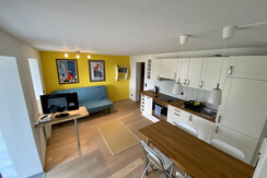 Wohnküche mit klappbarer Couch und Flatscreen-TV