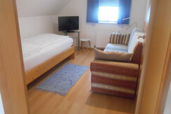 Das Schlafzimmer mit Einzelbett und Ausziehsofa