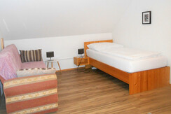 Zweites Schlafzimmer mit Einzelbett und Sofa