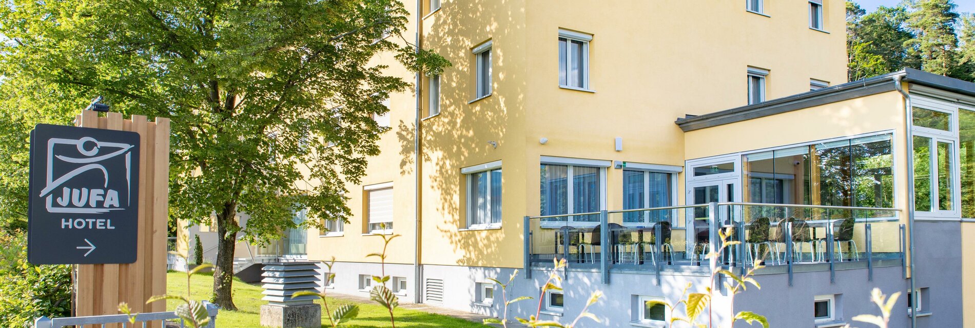 auenansicht-sommer-einfahrt-terrasse-jufa-hotel-ga