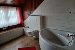 Spacious corner bathtub in the bathroom in the attic