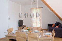 Dining table with TV corner in the background