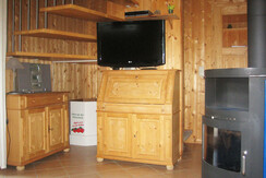 Wohnbereich mit Flat-TV und Kaminofen