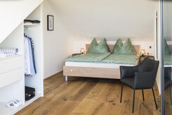 Schlafzimmer mit Doppelbett, Schrank und Ausblick