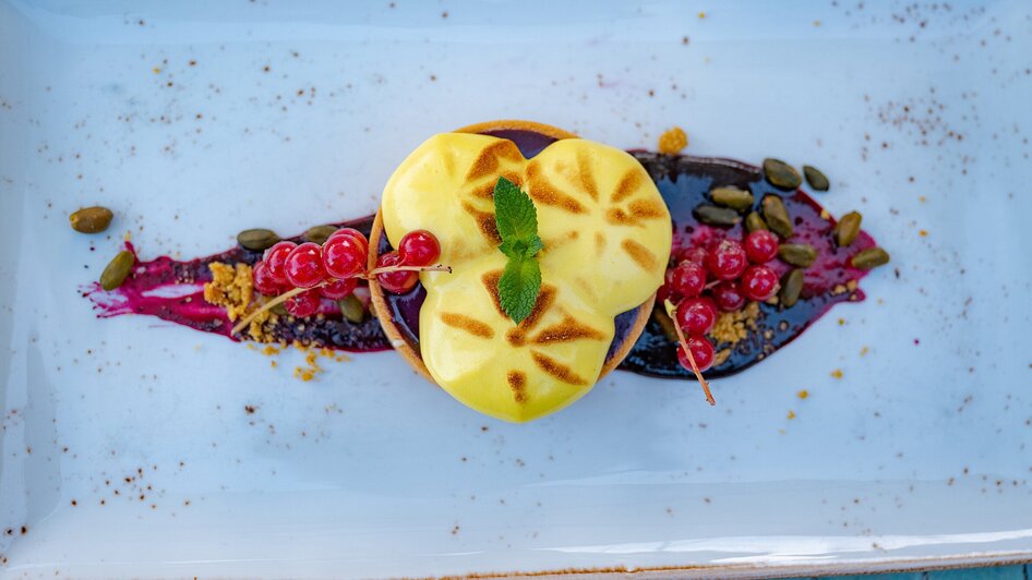 Ein kreatives Dessert im aiola im Schloss mit Fruchtsoße und Deko.