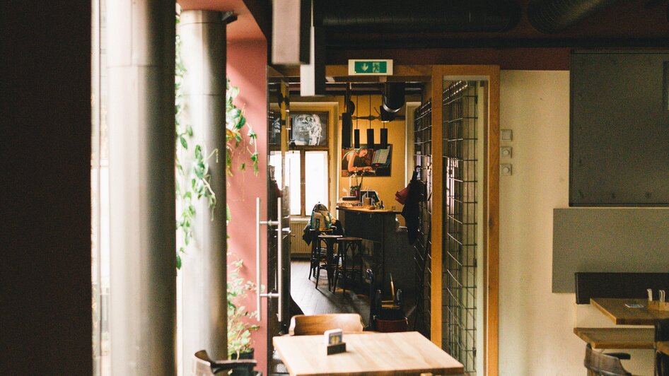 Innenansicht des Café Stockwerk in Graz - Jazzlokal mit Holztischen und Pflanzen.