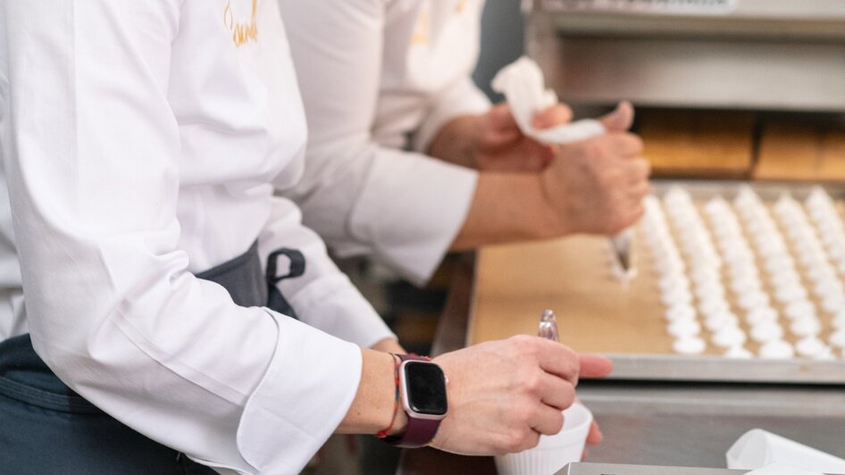 Zwei Köchinnen kreieren Desserts in einer modernen Küche.