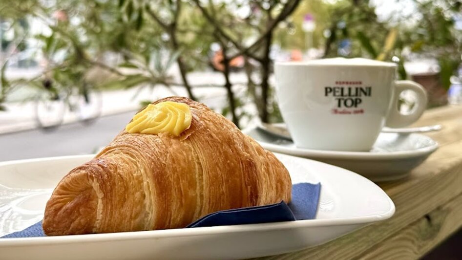 Ein Croissant und eine Tasse Kaffee bei Caffè Caramello in Graz.