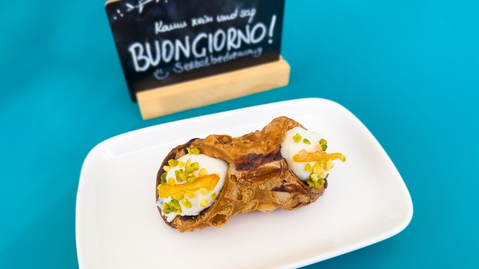 Ein köstliches Dessert mit einer Tafel im Hintergrund, die 'Buongiorno!' sagt.