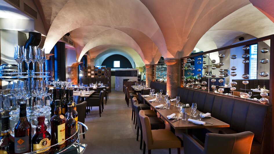 Elegante Restaurantansicht mit Tischen und Regalen für Getränke.