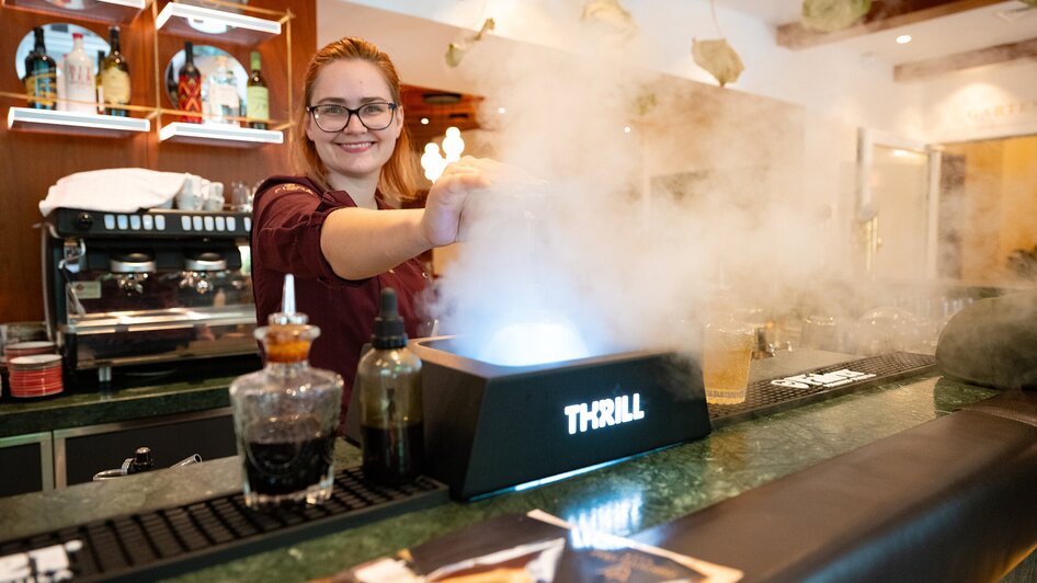 Eine Barkeeperin bereitet ein Getränk in einem eleganten Restaurant zu.