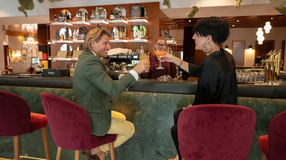 Paar genießt Cocktails an der Bar im Parkhotel Graz.