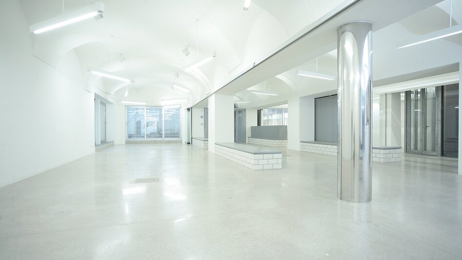 Heller, offener Raum im Haus der Architektur, mit Stahl- und Betonelementen.