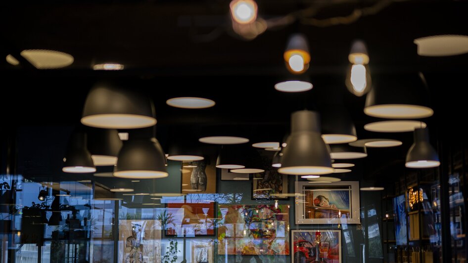 Künstlerische Wand mit Bildern in einem stilvollen Café.