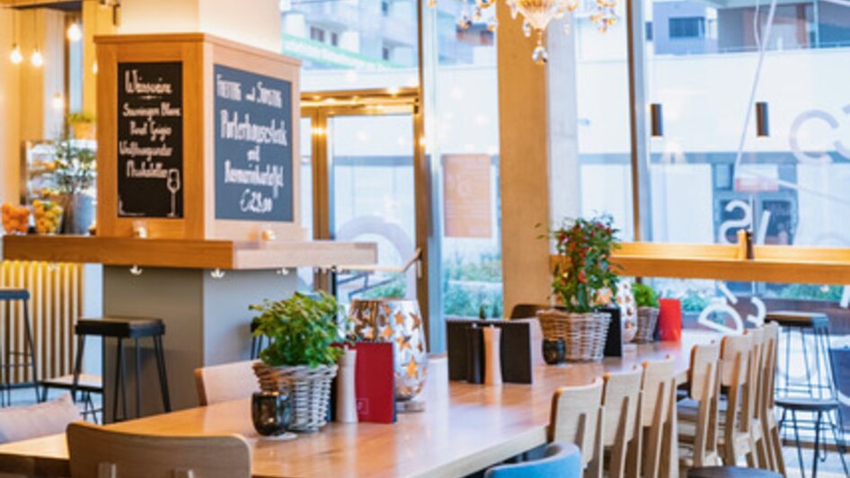 Modernes Restaurant mit eleganten Kronleuchtern und Holzdekor.