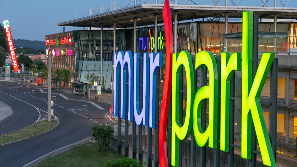 Beleuchtete Fassade des MURPARKS in Graz, Österreich.