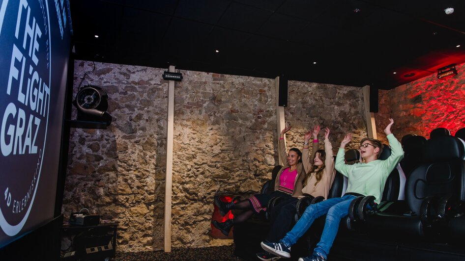 Gäste genießen ein 4D-Kinoerlebnis bei The Flight Graz.