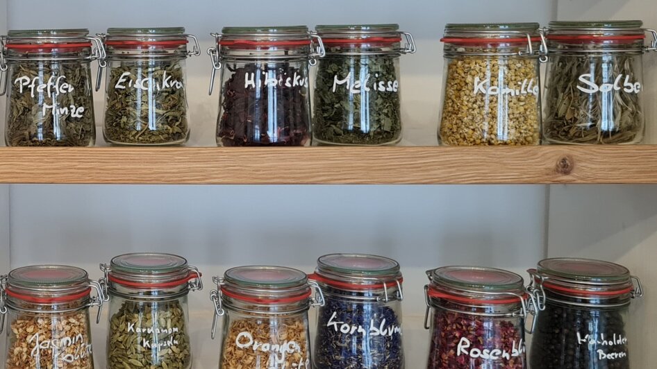 Gläser mit verschiedenen Kräutern und Gewürzen beschriftet auf Regalen.