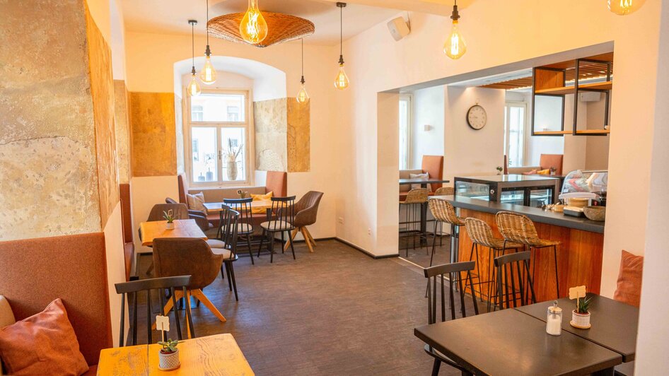Moderne Café-Atmosphäre mit bequemen Sitzplätzen und stimmungsvollem Licht. | © Mona Ramsenthaler