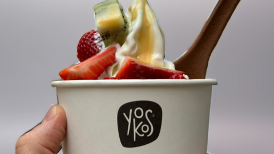 Eine Hand hält einen Becher mit Frozen Yogurt und frischen Früchten. | © hepac tourism GmbH