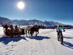 Fatbiker mit Pferdeschlitten im Hintergrund. | © alpinefatbike.com