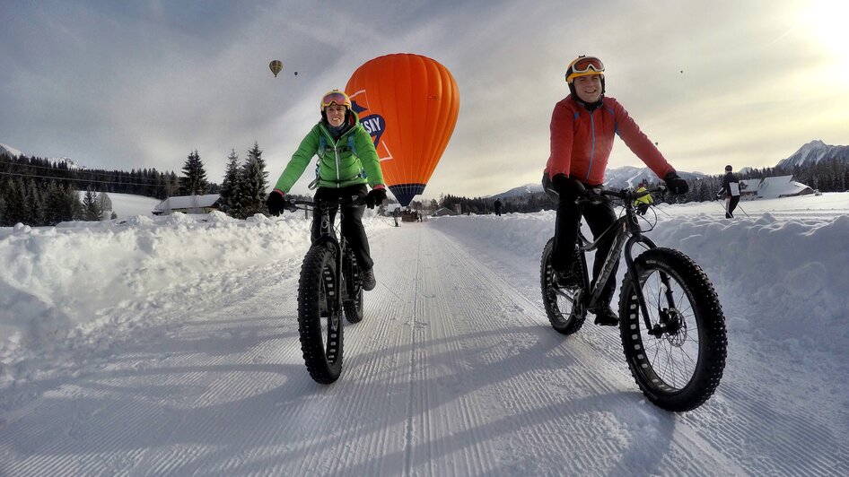 Fatbiker mit Heißluftballon im Hintergrund. | © alpinefatbike.com