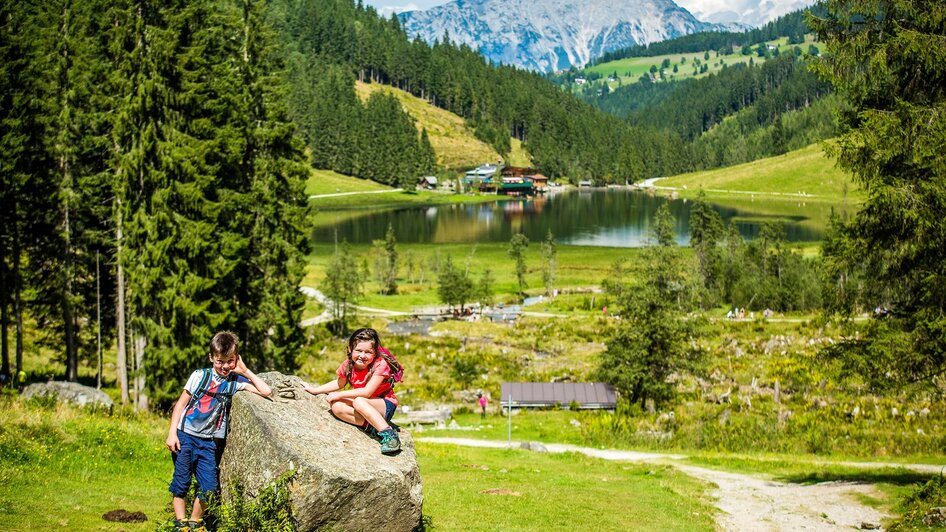 Kinder auf einem Stein vor dem Steirischen Bodensee | © TVB Haus-Aich-Gössenberg@René Eduard Perhab