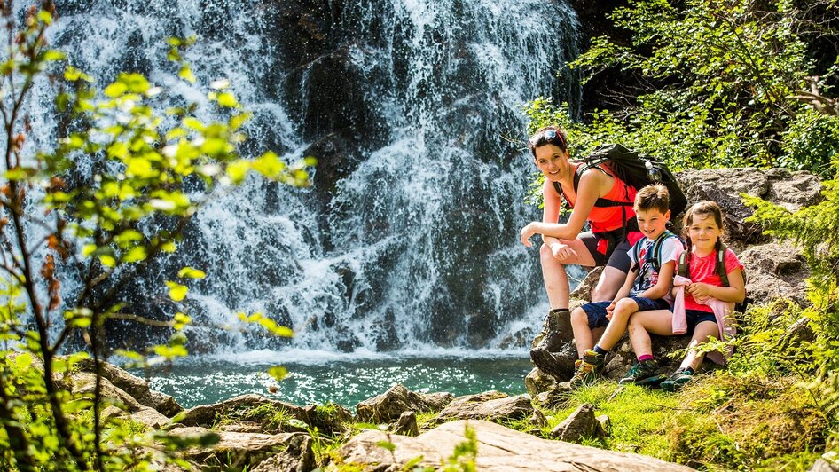 Mutter mit Kindern vor einem Wasserfall | © TVB Haus-Aich-Gössenberg@René Eduard Perhab